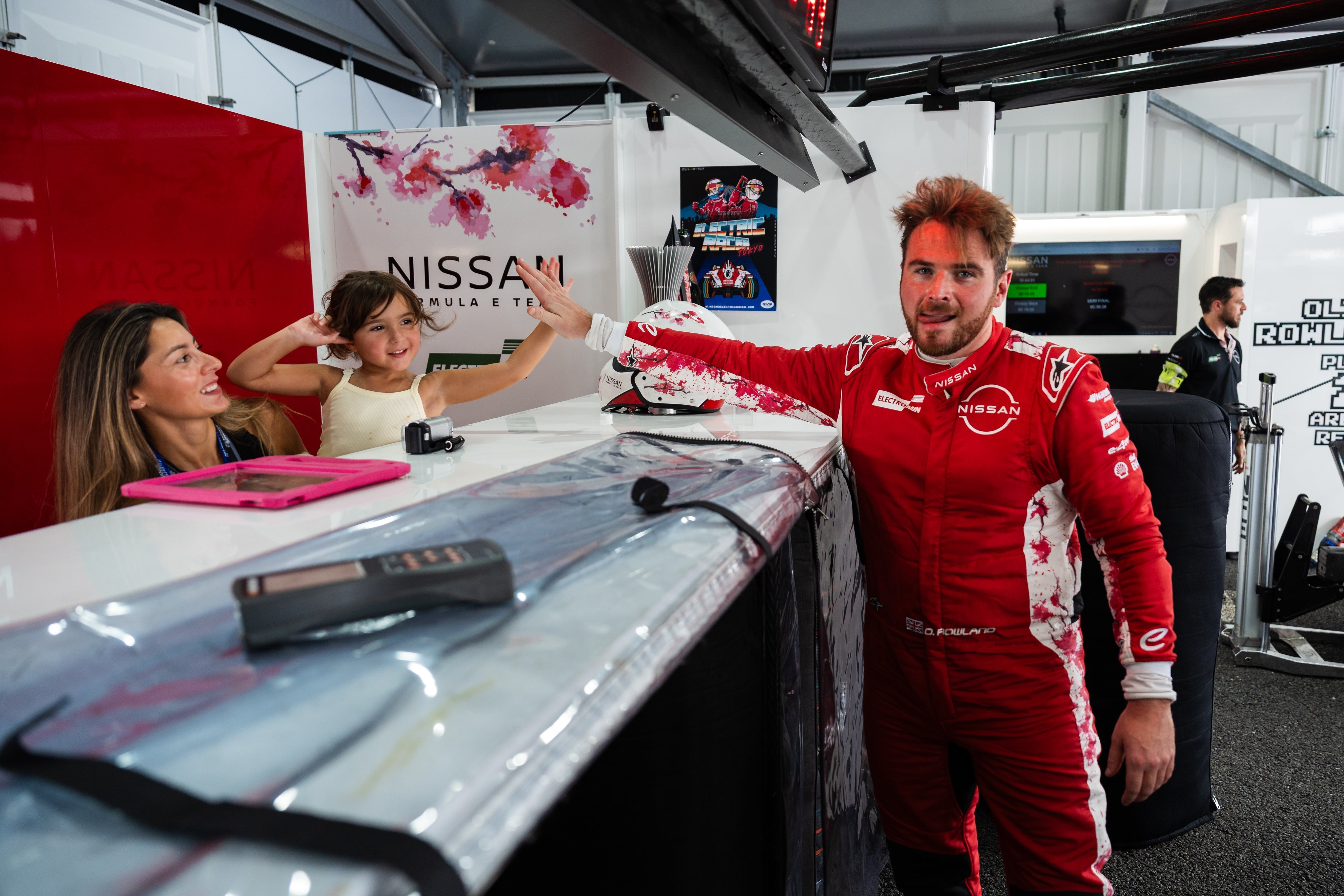 Nissan Formula E driver Oliver Rowland high fives his daughter Harper in the Nissan garage at the Tokyo E-Prix.