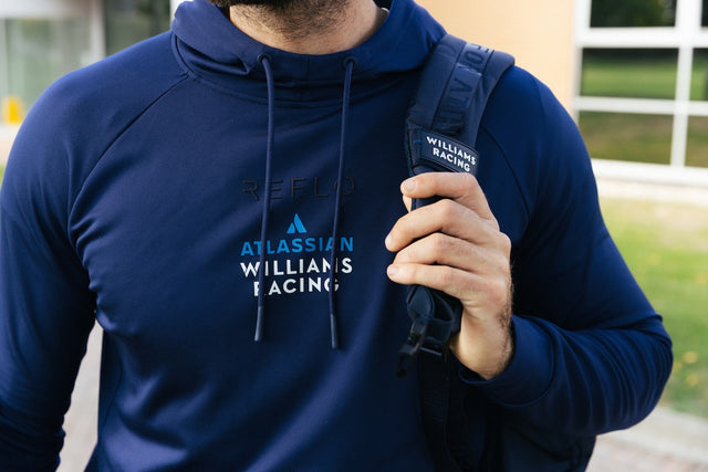 Model wearing a Atlassian Williams Racing navy hoodie carrying a backpack
