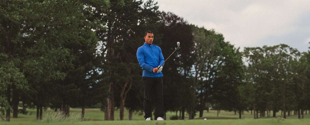 A man playing golf while wearing Reflo clothing