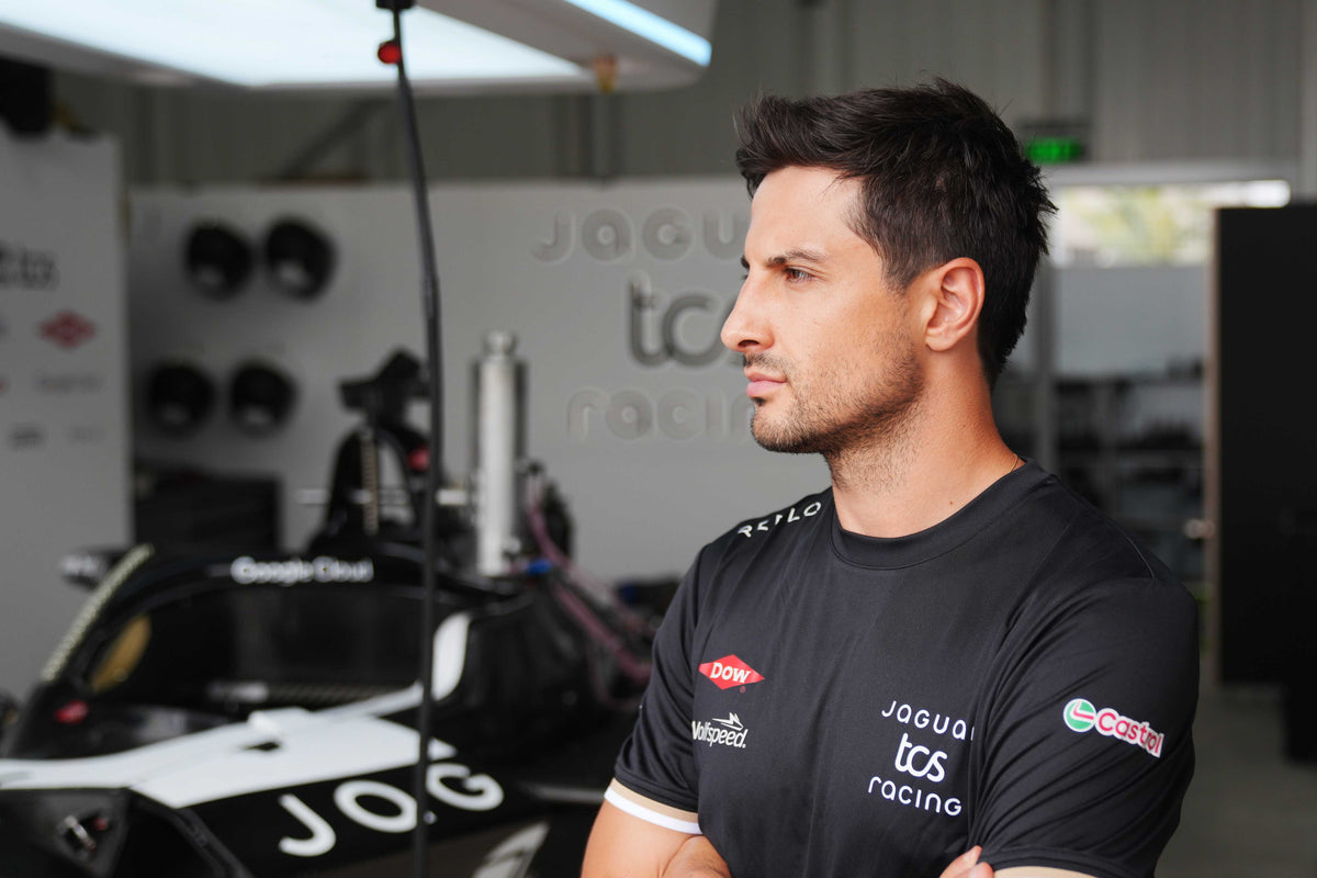 Person wearing a Reflo made Jaguar TCS Racing shirt in a garage setting