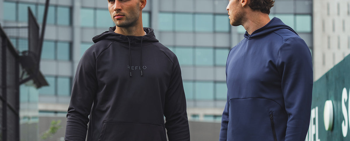 Two men wearing Reflo hoodies while playing Padel