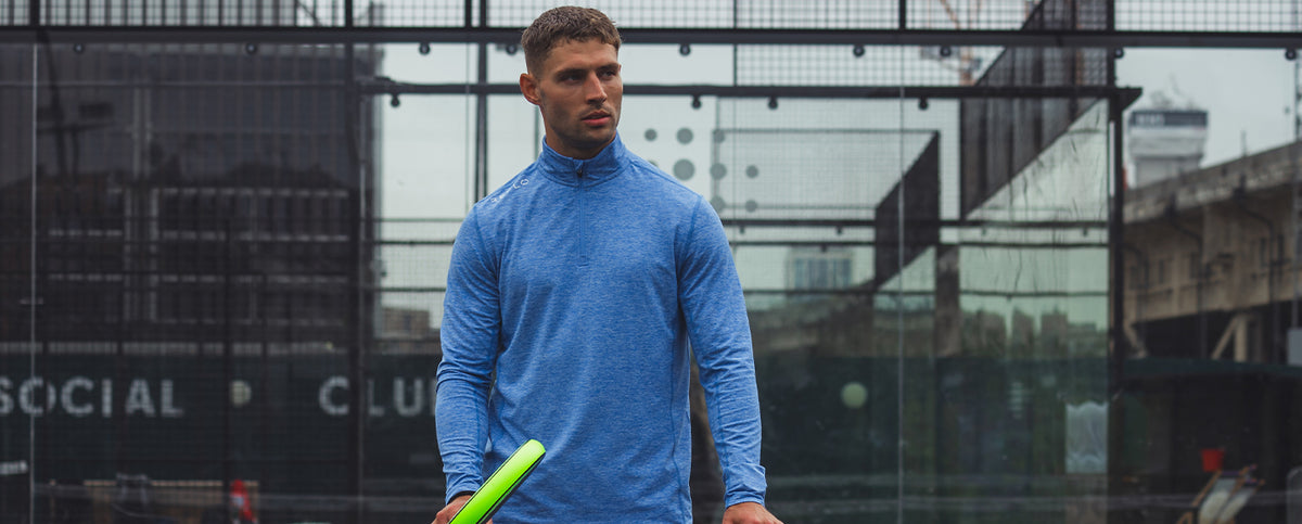 A man wearing a Reflo midlayer while playing Padel