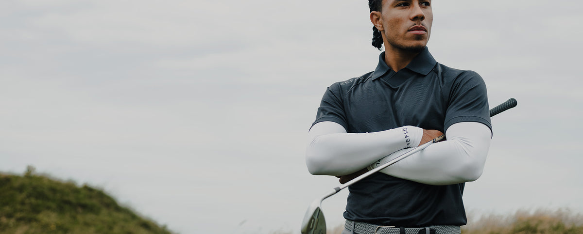 A man wearing a Reflo polo shirt and underlayer to play golf